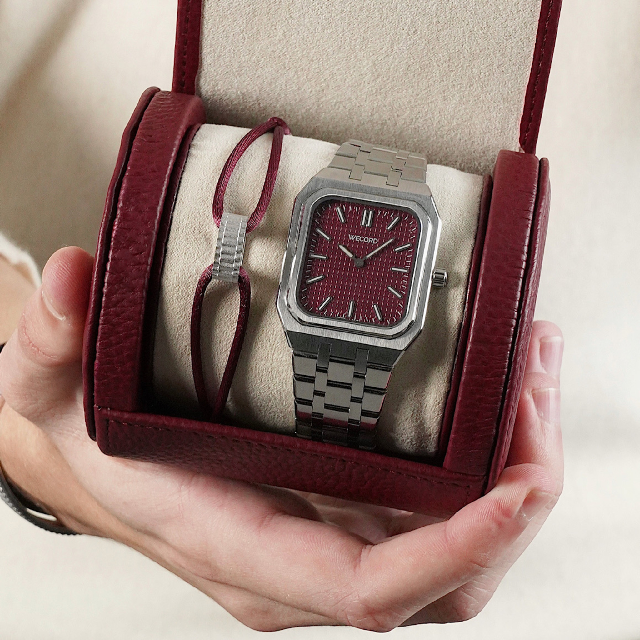 Wecord Oliver square watch with burgundy dial paired with a red cord bracelet in a Kensington leather watch roll